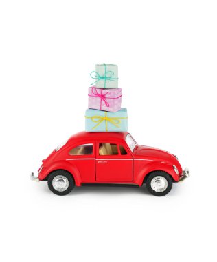 Çatısı hediyelerle dolu parlak kırmızı bir oyuncak araba, neşeli ve şen bir atmosfer sunuyor. Tatil kutlaması için mükemmel..