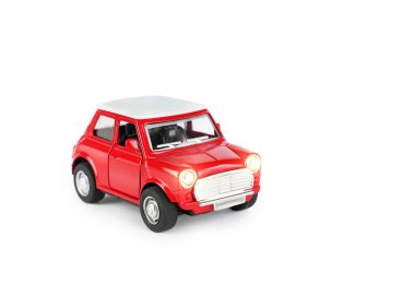 Beyaz çatılı parlak kırmızı bir oyuncak araba temiz beyaz bir arka plana karşı konumlandırılmıştır. Arabanın farlar da dahil olmak üzere ayrıntılı özellikleri var ve eğlenceli aktiviteler için yapılmış..