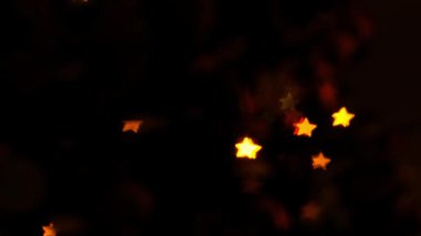 Yumuşak ışıklar karanlıkta parlar. Ağaca yıldız şeklinde süslemeler asılmış. Sıcacık parıltı ortamı şenlikli ve misafirperver kılıyor..