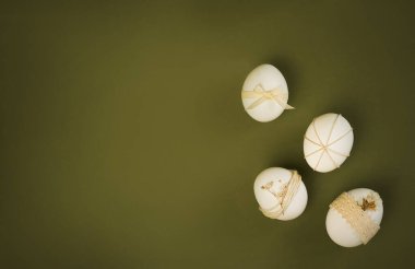 Yumurtalar Paskalya için basit tasarımlar ve desenlerle süslenir. Yeşil bir yüzeye yerleştirilmişler. Sahne geleneksel Paskalya kutlamalarını temsil ediyor.