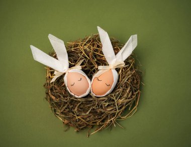 İki yumurta samandan yapılmış bir yuvada oturur. Yumurtaların kurdeleleri ve tavşan kulaklarını andıran kumaşları var. Bu sahne Paskalya kutlamalarını ve zanaatkarlığı yansıtıyor..