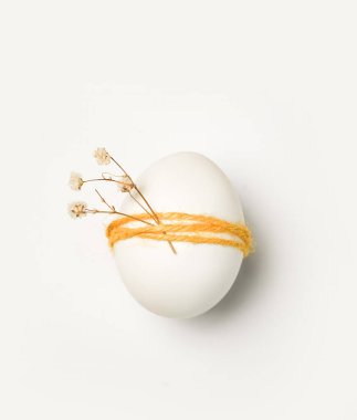 Paskalya kutlamasında renkli iplikle sarılmış beyaz yumurtalar yer alıyor. Küçük kurumuş çiçekler yumurtalara bağlıdır. Bu sahne, geleneksel şenlik dekorasyonlarına odaklanarak ilkbaharda geçiyor..