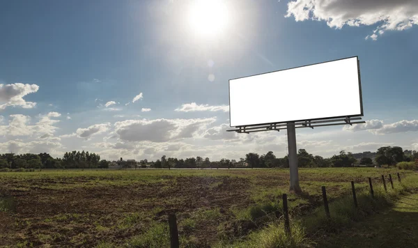 Cartelera vacía frente al hermoso cielo nublado en una ubicación rural — Foto de Stock