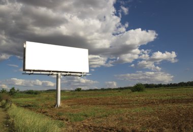 Kırsal bir yerde güzel bulutlu gökyüzü önünde boş billboard