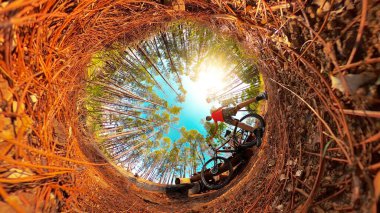 Yeşil parkta salgın maskeli ve bisikletli siyah bir adam. Pandemik konsept görüntüsünde korunan spor.