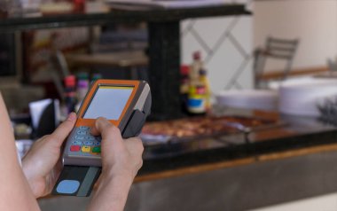 Bir restoranda kredi kartı ödeme slayt makinesi bulundurmak. 