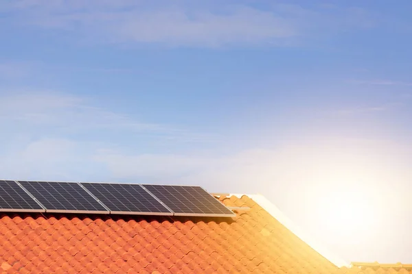 Solar photovoltaic panels on a roof at sunset. Clean energy modern house or company concept image.