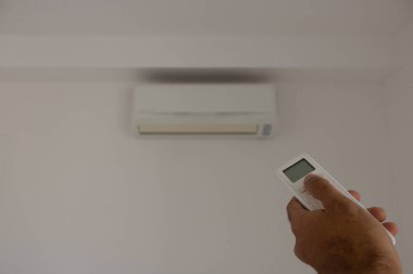 Arka plandaki bulanık oturma odasında uzaktan kumandalı klima..