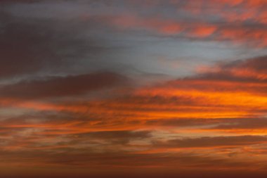 Bulutlu bir kış gününde kırmızı renkli ateşle gün doğumu gökyüzü.