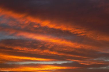 Bulutlu bir kış gününde kırmızı renkli ateşle gün doğumu gökyüzü.