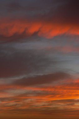 Bulutlu bir kış gününde kırmızı renkli ateşle gün doğumu gökyüzü.