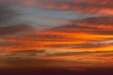 Bulutlu bir kış gününde kırmızı renkli ateşle gün doğumu gökyüzü.