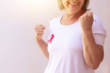 Beyazda pembe kurdeleli olgun bir kadın. Meme Kanseri Farkındalığı Ay resmi. 