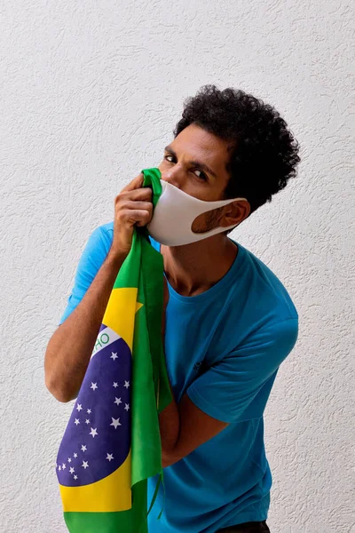 Czarny Człowiek Maską Pandemiczną Trzymając Flagę Brazylii Odizolowany Białym — Zdjęcie stockowe