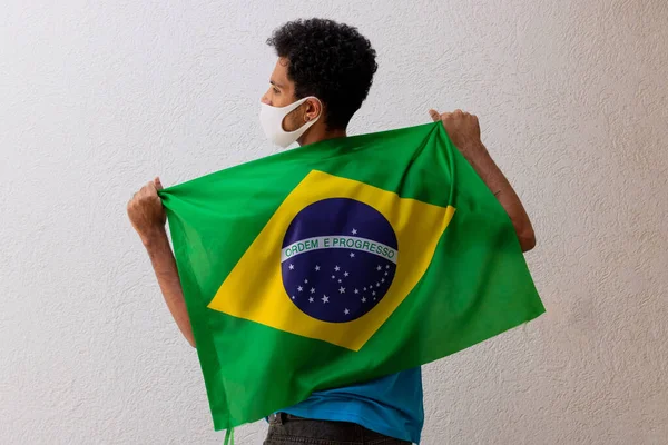 Homem Negro Com Máscara Pandêmica Segurando Uma Bandeira Brasil Isolada — Fotografia de Stock