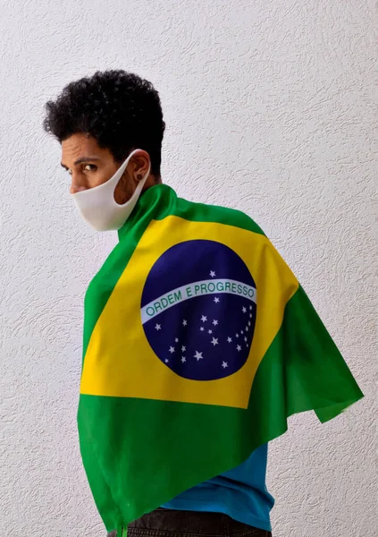 Μαύρος Πανδημική Μάσκα Κρατώντας Μια Σημαία Της Βραζιλίας Απομονωμένη Λευκό — Φωτογραφία Αρχείου