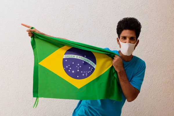 Homem Negro Com Máscara Pandêmica Segurando Uma Bandeira Brasil Isolada — Fotografia de Stock