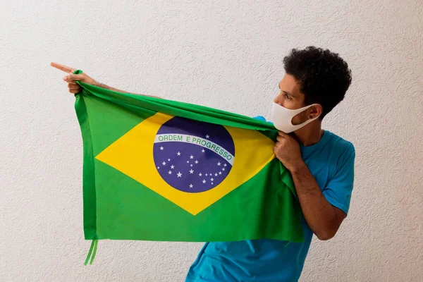 Homem Negro Com Máscara Pandêmica Segurando Uma Bandeira Brasil Isolada — Fotografia de Stock