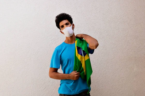 Hombre Negro Con Máscara Pandémica Sosteniendo Una Bandera Brasil Aislada —  Fotos de Stock