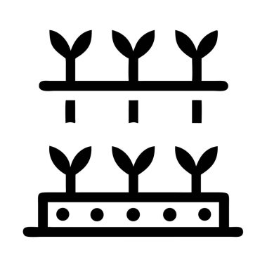 Siyah bir ikon, iki katmanlı bir bahçe yatağı ve tohum veya toprağı temsil eden şekillendirilmiş bitkiler ve noktalar gösterir..