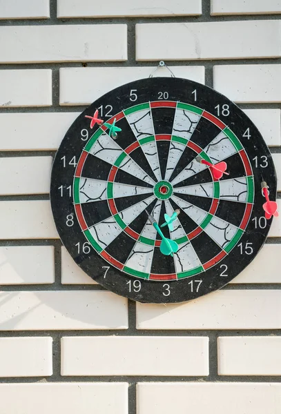 Dart oyunu beyaz tuğlalı duvarda skorlar ve kaymalarla