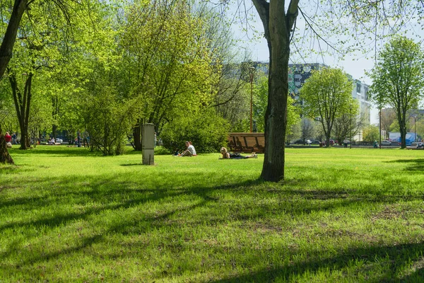 ロシア カリーニングラード2021年5月10日 暖かい春の日にカンツ島の公園で草の上に横になって座って — ストック写真