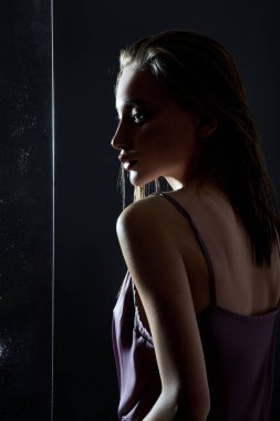 Yağmur damlalarının camının yanında ıslak saçlı güzel bir kadın. Doğal kozmetik ve makyaj