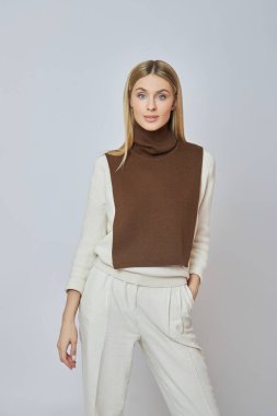 Boynunda önü olan sarışın bir kadın. Sonbahar havası için kıyafet. Güzel doğal makyaj.