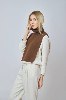 Boynunda önü olan sarışın bir kadın. Sonbahar havası için kıyafet. Güzel doğal makyaj.