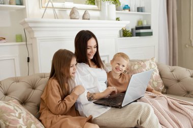 Anne kız ve oğlu dizüstü bilgisayarda oynuyorlar. Aile eğlencesi ve eğlence.