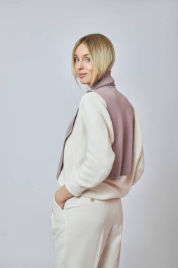 Boynunda önü olan sarışın bir kadın. Sonbahar havası için kıyafet. Güzel doğal makyaj.