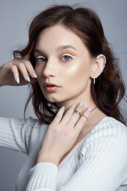 Doğal makyajlı ve eline oje sürmüş bir kadının güzel portresi. Ellerinde yüzükler