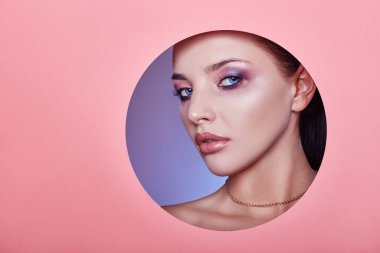 Güzel tombul dudaklar parlak pembe renk, kadın yuvarlak delikte pembe kağıt, güzellik salonu. Makyaj, reklam yüz bakımı, mükemmel dudaklar, moda güzellik makyajı ve kozmetik.