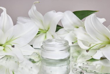 Masada nilüfer çiçekleri olan güzellik kavanozu kremi, ıslak çiçek aynası nemlendiricisinde kavanoz kremi. El bakımı için doğal çiçek kavanozu kremi. Pürüzsüz güzel cilt