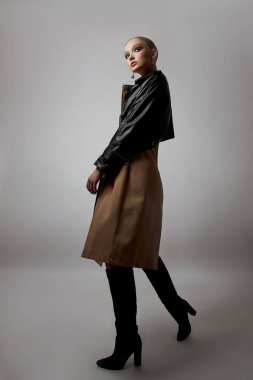 Trençkotlu genç bayan, profesyonel makyajcı kız. Beyaz arka planda kadın portresi. Yağmurlu havada bahar giysileri