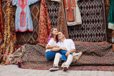 Aşık bir çift, Türkiye 'deki bir doğu pazarından el yapımı halı ve tekstil satın alıyor. Sarılmalar ve kadın ve erkeklerin neşeli mutlu yüzleri