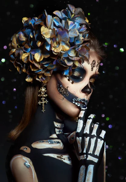 Halloween beauty portrait of a skeleton woman of death Bokeh glitter, the makeup on the face. Girl death Halloween costume. Day of The Dead. Charming and dangerous Calavera Catrina