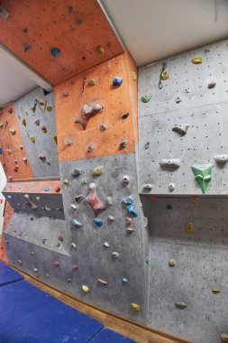 Several climbing surfaces showcase a variety of holds in bright colors, designed for indoor climbing training. walls provide different challenges for climbers of all skill levels.