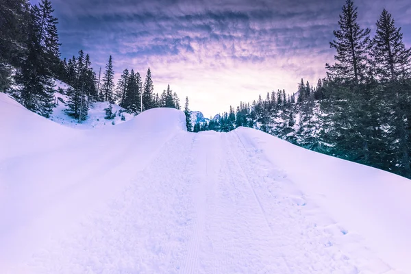 Route de montagne à travers des tas de neige — Photo