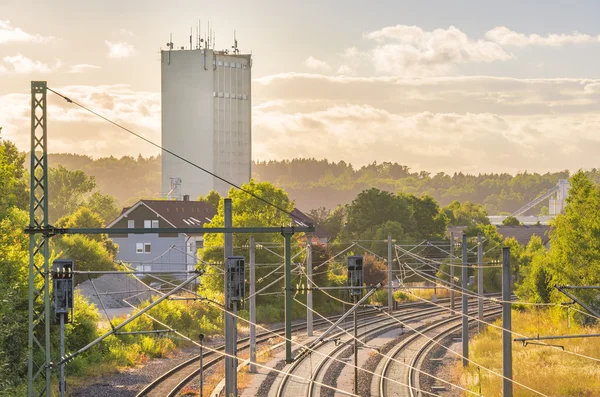 Железные дороги рядом с промышленной башней и зданиями — стоковое фото