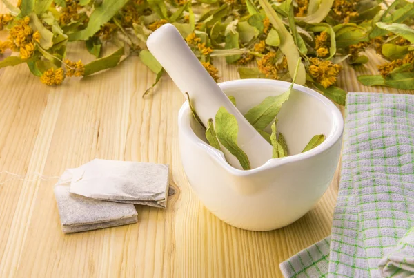 Flores de tilo en un mortero y bolsas de té —  Fotos de Stock