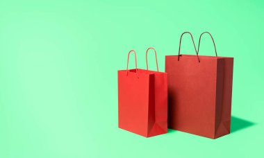 Yeşil nanesiz arka planda izole edilmiş kağıt alışveriş torbaları. Alışveriş tanıtım broşürü. Almak için kırmızı kese kağıdı. Çevre dostu alışveriş paketleri.