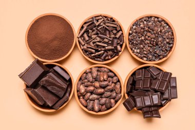 Kakao tozu, kakao fasulyesi ve bej arka planda izole edilmiş çikolata parçaları. Sütlü çikolata çeşitleriyle yatıyordu. Çikolata aşamaları konsepti.