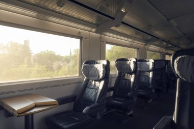Güneşli bir günde hareket halinde, içi boş koltukları olan birinci sınıf bir tren. Yolcu treni, Alman şehirlerarası ekspres treni. Business class 'ta toplu taşıma