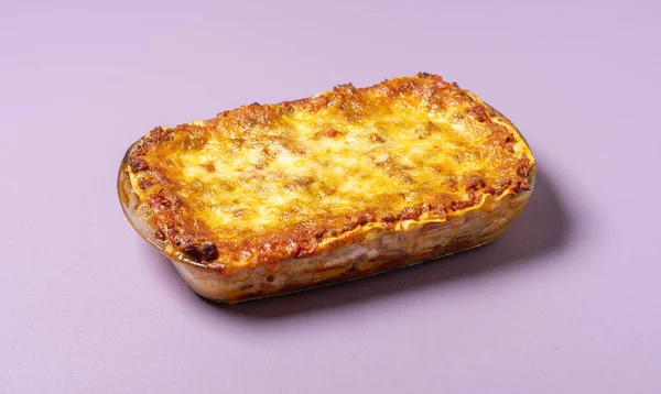 トレイに肉ラザニア 焼きたて 紫の背景に 自家製の伝統的なイタリアのラザニアミンチ肉 溶融モッツァレラチーズとトマトソース — ストック写真