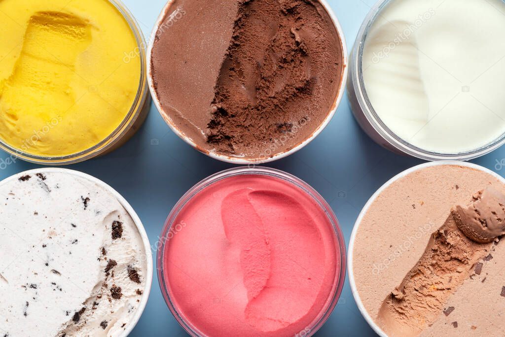 Top view with various types of ice cream. Containers with different kinds of ice cream and sorbet, above view.