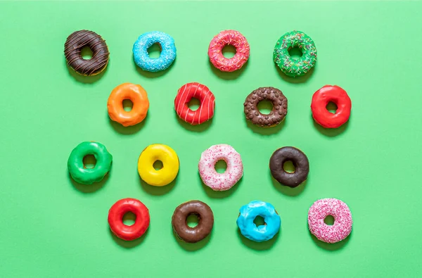 Шоколадные Пончики Красочной Глазурью Изолированы Зеленом Фоне Плоский Лежал Множеством — стоковое фото