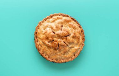 Yeşil bir masada ev yapımı elmalı turta. Lezzetli ev yapımı elmalı tart, renkli bir arka planda minimalist..