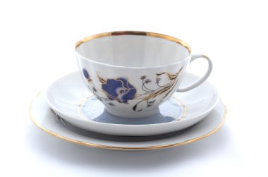 Porselen bardak, tabak ve beyaz bir arka plan üzerinde uçan daire