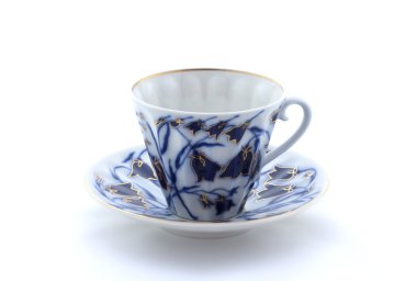 Beyaz arka planda porselen bardak ve çay tabağı.